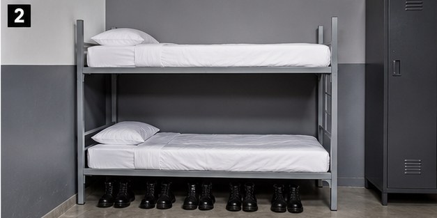 Cama institucional en cuartel con botas alineadas