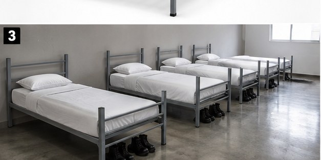 Dormitorio institucional con múltiples camas grises